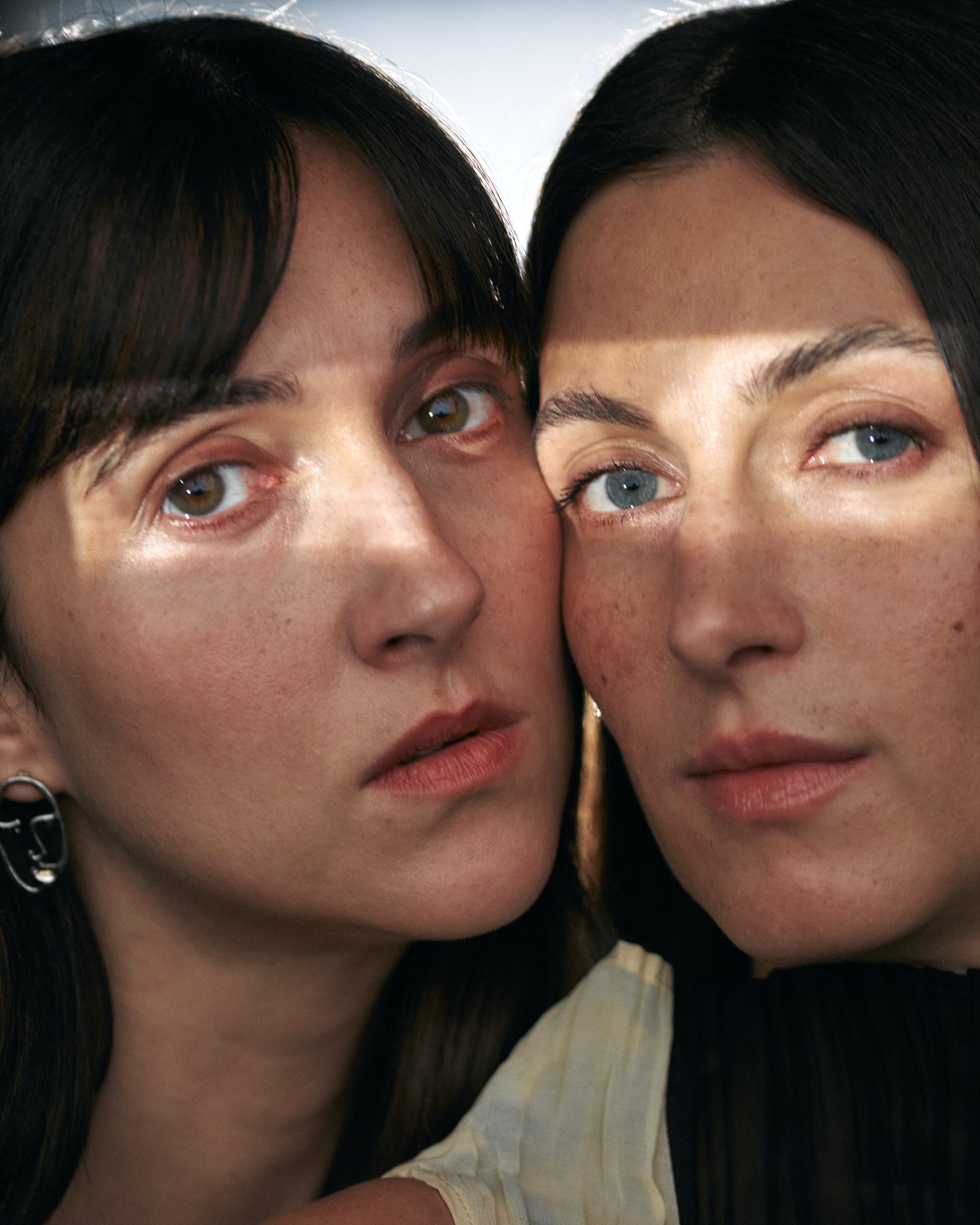 Close-up portrait of Kim and Flo Nüesch with their faces side by side, looking directly at the camera.