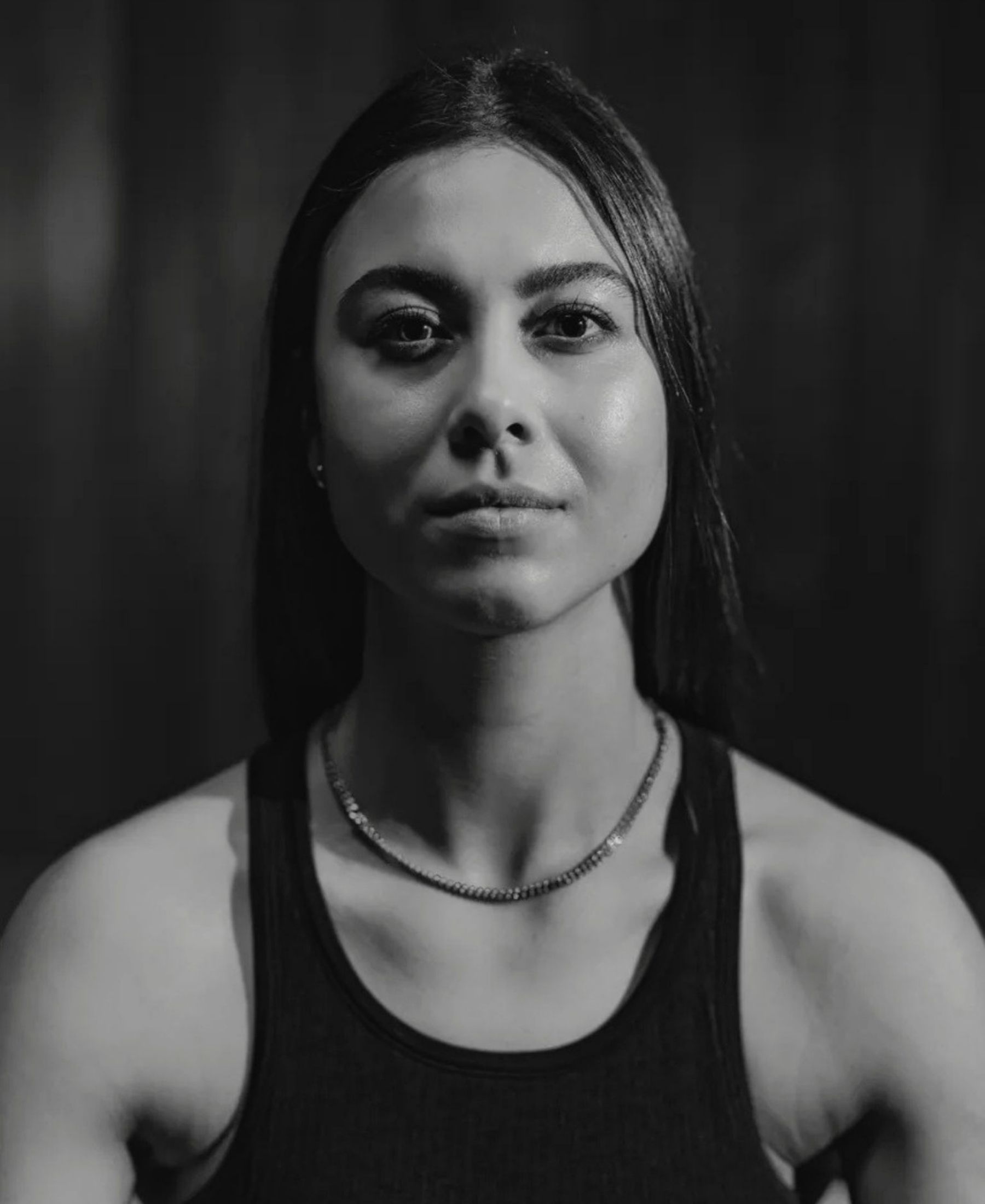 Black-and-white portrait of Franzisca Gartenmann with long dark hair, wearing a sleeveless top and fine chain necklace.